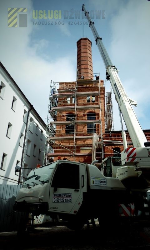 prace budowlane przy renowacji komina przy użyciu dźwigu
